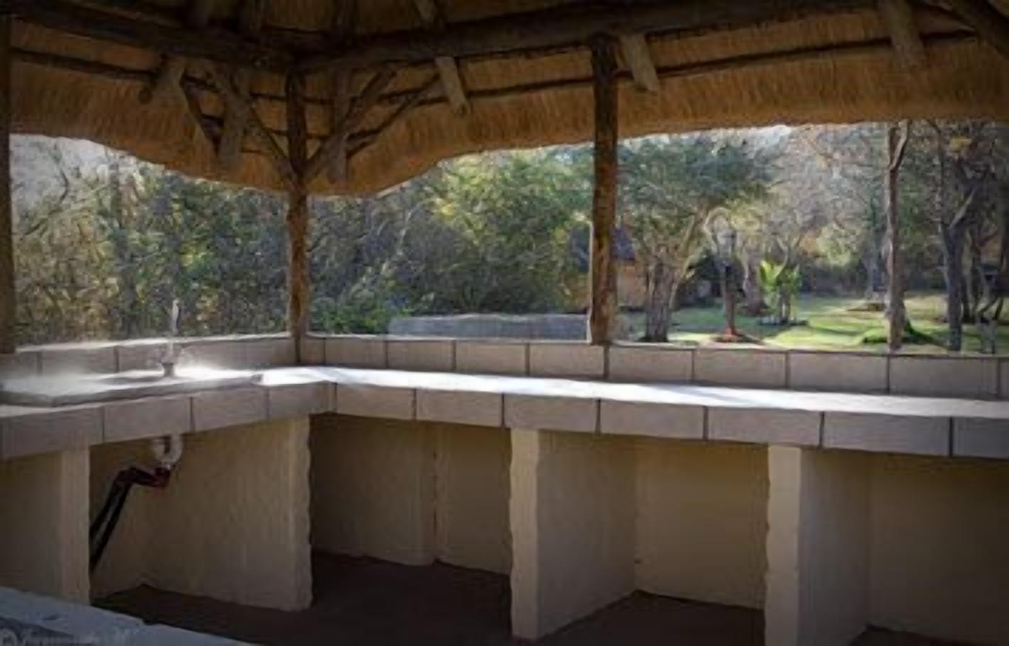 A room with a concrete bench and a window overlooking a garden.
