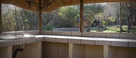 A room with a concrete bench and a window overlooking a garden.