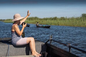 A person on a boat taking a photo with a camera.