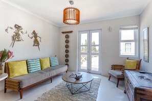 A living room with a sofa, coffee table, and a decorative wall piece. - 211 De Waterkant (Cape Town)