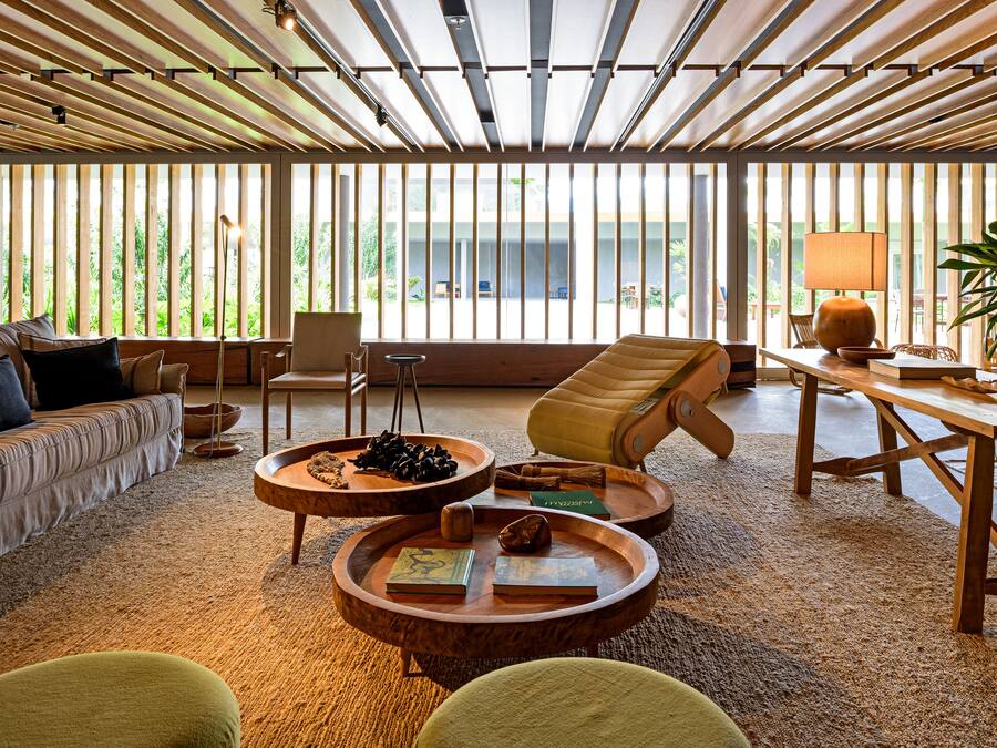 A spacious living room with a large window, a sofa, a coffee table, and a chair.