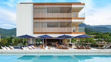 Relax by the pool surrounded by lounge chairs and umbrellas, with breathtaking views of the surrounding mountains.