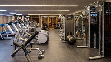 A gym with treadmills, elliptical machines, weight machines, and a squat rack.