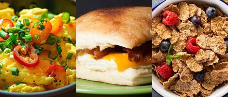 A breakfast dish with scrambled eggs, bacon, and cheese, a sandwich with a bun, and a bowl of cereal with berries.