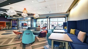 A modern lounge area with seating arrangements, tables, and decorative lighting fixtures.