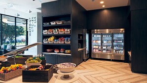 Un área de cocina moderna con una isla central, un refrigerador y diversos alimentos en estantes.
