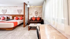 Une chambre d’hôtel avec un lit, un canapé, une table à manger et une grande fenêtre avec des rideaux.