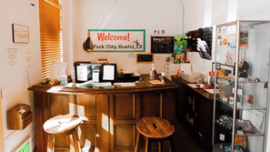 A reception desk with a 'Welcome! Park City Hostel' sign, a computer, and a bulletin board with various notices. - Park City Hostel (Park City)