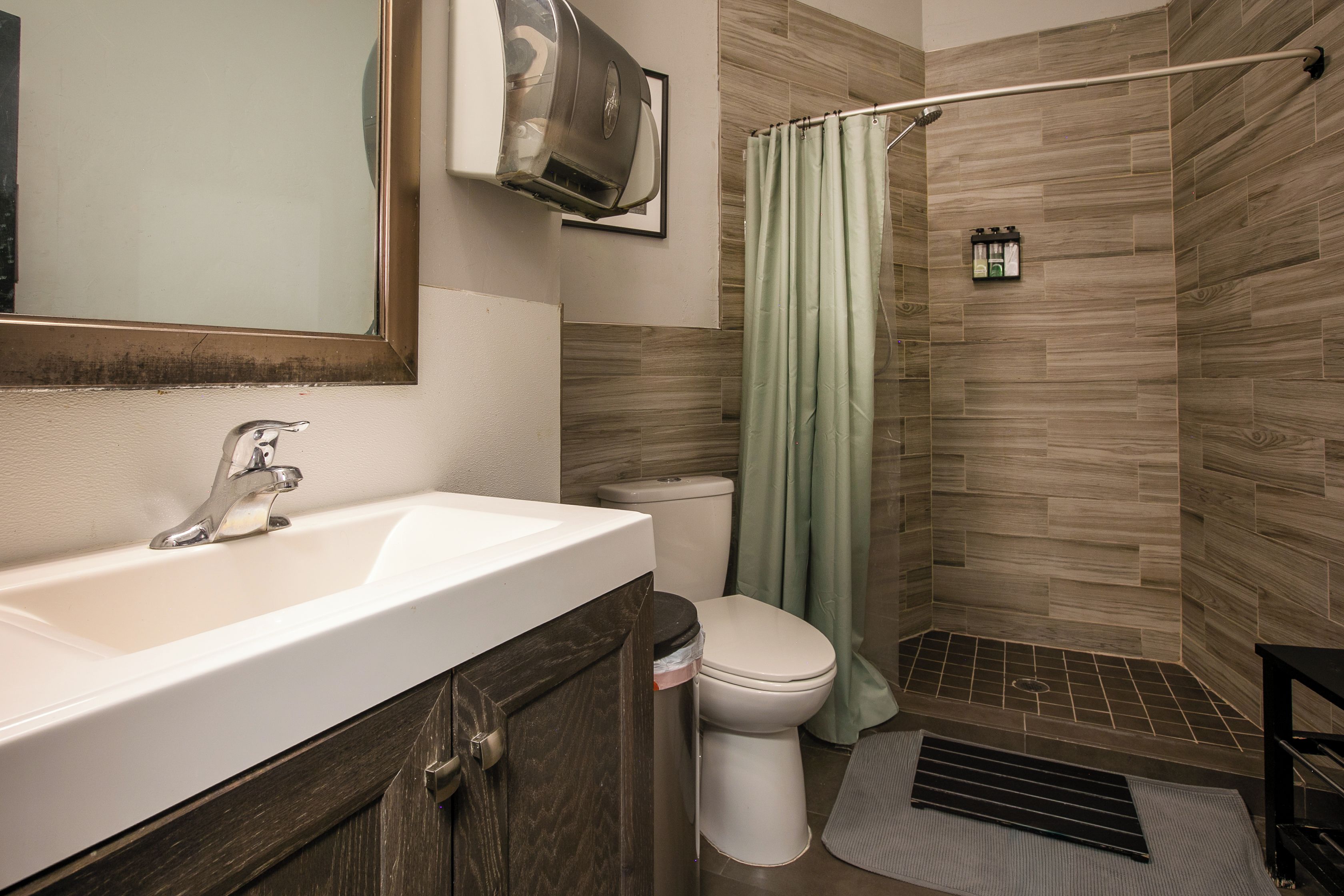 A bathroom with a sink, toilet, shower, and a towel rack.