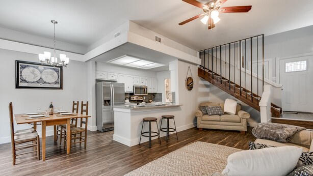 A spacious living area with a dining table, kitchen, and a staircase. - South Austin Creekside Retreat!  (Austin)