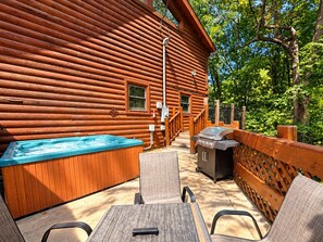 A log cabin with a hot tub, outdoor grill, and seating area. - Elevator + Roll-In Shower | Theater + Game Room (Pigeon Forge)