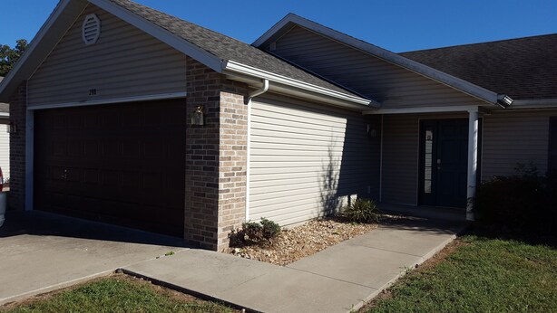 A single-story house with a garage, a brick foundation, and a front door. - 3 bedroom, 2 bath house. Sleeps 6. Close to 76 Hwy strip (Branson)