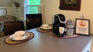 A dining area with a coffee maker, cups, and a framed sign about farm fresh eggs. - Cozy Country Apartment in Heart of Geauga County (Newbury)