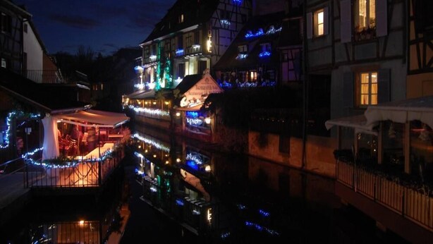 A traditional European building with a restaurant on the ground floor, illuminated by warm interior lighting. - Apartment/ flat - Colmar (Colmar)