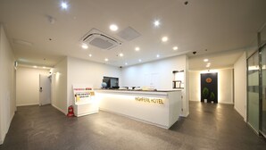En receptionsdisk med en skylt som visar texten ”HIGHFERE HOTEL” i en modern hotellobby med en stilren och minimalistisk design.
