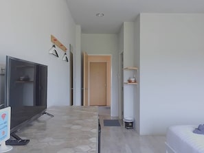 A modern hotel room with a flat-screen TV, a desk, and a bed.