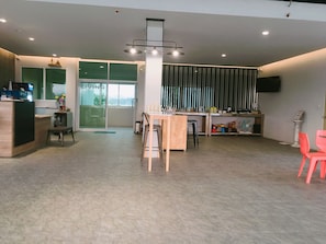 A modern kitchen with a dining area, a bar, and a large window.