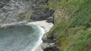 Eine Küstenlandschaft mit Sandstrand und Felsen.