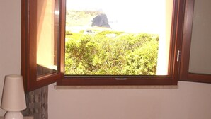 Ein Schlafzimmer mit einem Fenster, das einen natürlichen Ausblick bietet.