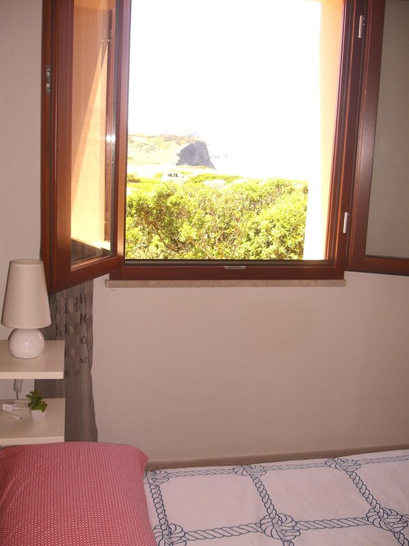 A bedroom with a window overlooking a natural landscape. - Wonderful view of the sea. Romantic and relaxing place suitable for a couple. (Sassari)