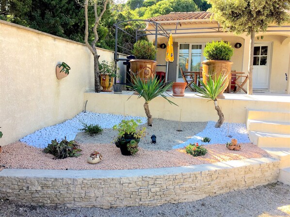 A garden with various plants and a stone wall.