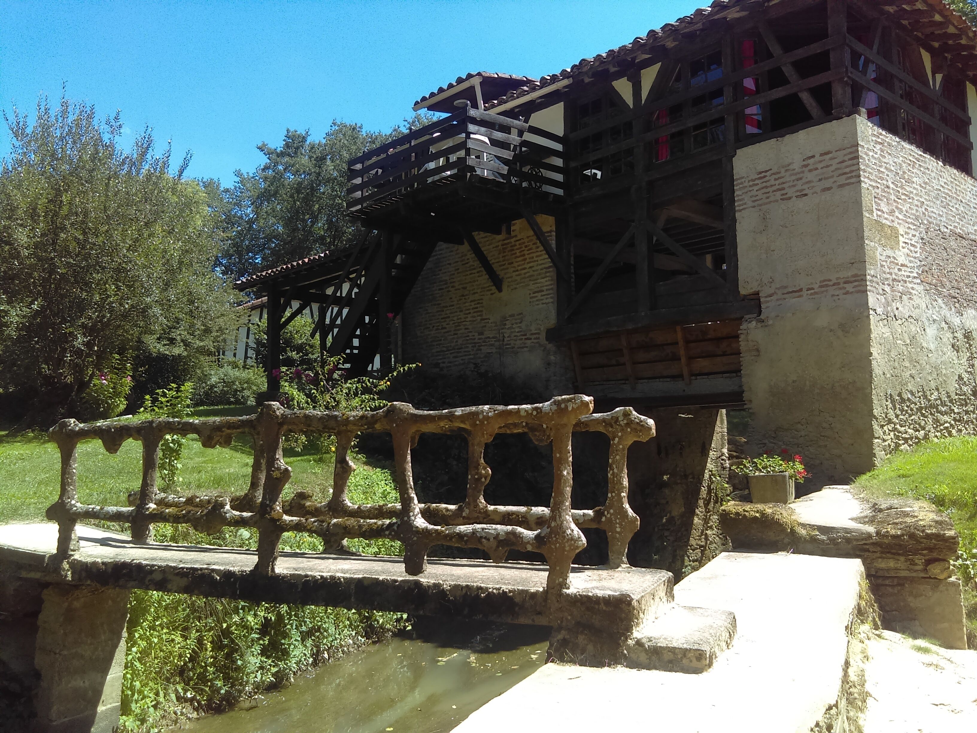 Un bâtiment historique doté d’un balcon en bois et d’un pont de pierre à l’avant.