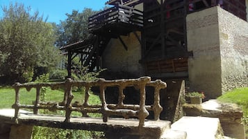 A historic building with a wooden balcony and a stone bridge in front.
