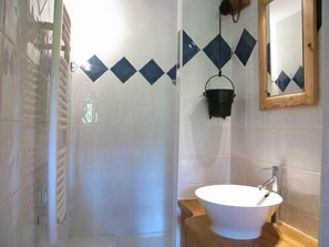 Une salle de bain avec un lavabo blanc, un meuble-lavabo en bois et un miroir.