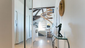 A modern interior with a spiral staircase, a glass partition, and a statue on a glass table. - The bright and colorful Duplex Mill in Saint-Rémy-de-Provence (Saint-Rémy-De-Provence)