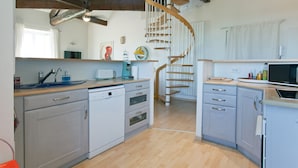 A kitchen with wooden beams, a spiral staircase, and modern appliances. - The bright and colorful Duplex Mill in Saint-Rémy-de-Provence (Saint-Rémy-De-Provence)