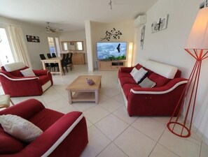 A modern living room with red sofas, a coffee table, and a TV. - La Cèzenole | Villa 5* air-conditioned Bungalow | Heated pool | Gorges Cèze (Méjannes le Clap)