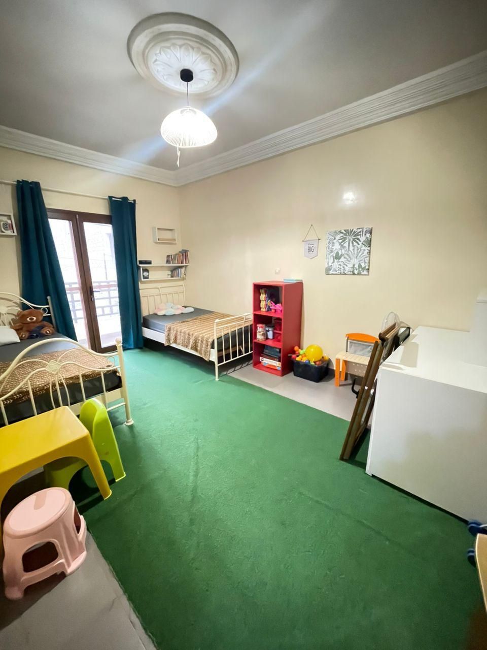 Habitación infantil con literas, escritorio, silla y una mesita.