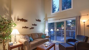 A living room with a sofa, coffee table, and two chairs. There are wall-mounted fish decorations and a potted plant. - 3 bed 2 bath, Wifi, Cable, Pool/Hot Tub, BBQ, Mini Golf, Beach, license#00005785 (Parksville)