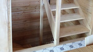 Eine Holztreppe mit Metallgeländer, die zu einer Ebene weiter unten führt.
