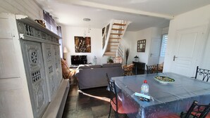 A dining area with a table, chairs, and a staircase leading to another level.
