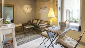 Un salon confortable avec un canapé, une table à manger et une lampe.