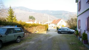 A rural road with parked cars, houses, and mountains in the background. - Apartment 6-10 p, quiet, close to resorts and nature, Wifi, cleaning and sheets included (Fellering)