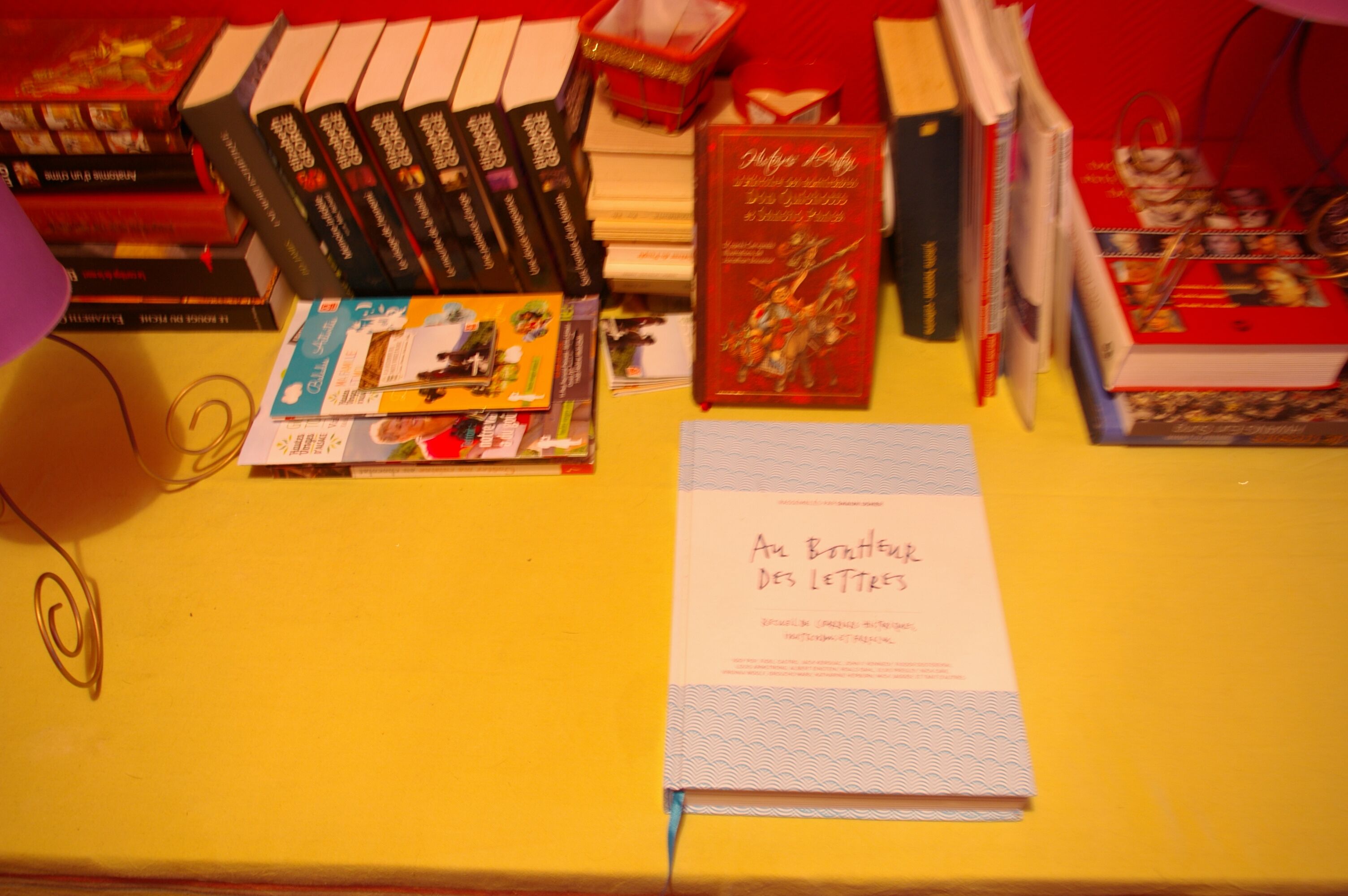 A table with books and a book titled "Al Boukher des Lettres".