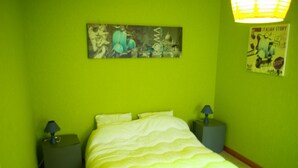 A room with a bed, two nightstands, and a wall with two posters. - Apartment 6-10 p, quiet, close to resorts and nature, Wifi, cleaning and sheets included (Fellering)