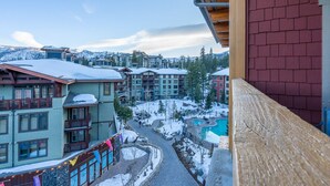 Une station de ski enneigée comprenant plusieurs bâtiments, une piscine et offrant une vue dégagée sur les montagnes environnantes.