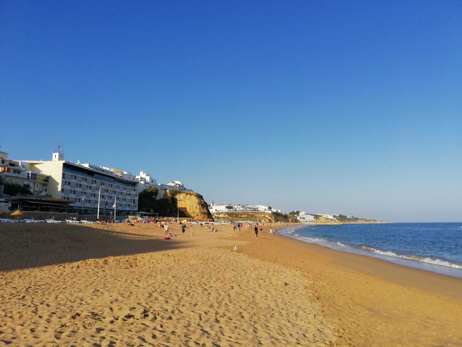 Une plage avec un hôtel en arrière-plan.