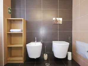 A modern bathroom with a wooden shelf, a bidet, a toilet, and a hand dryer. - Fantastic apartment for lovers, friends or family vacations (Albufeira)