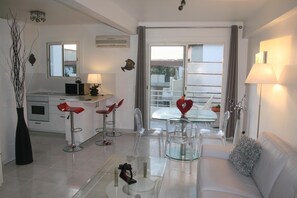 A modern kitchen with a microwave, a coffee machine, and a dining area with a glass table and chairs. - Large luxury studio on the Promenade des Anglais, 20 metres from Negresco (Nice)