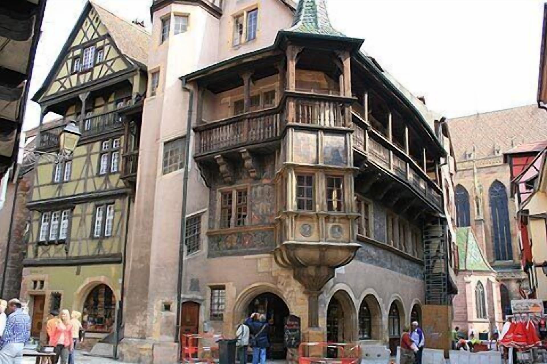 A historic building with multiple stories, a prominent balcony, and a traditional architectural style.