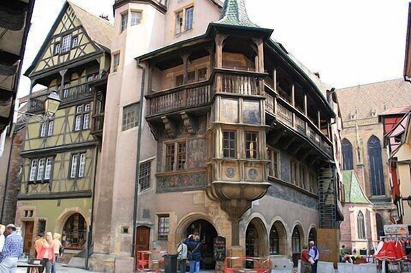 A historic building with multiple stories, a prominent balcony, and a traditional architectural style.