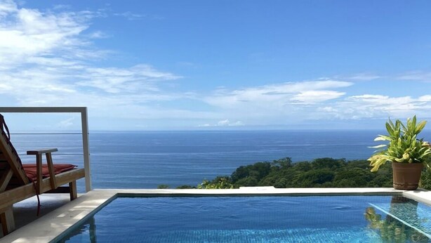 Ein Pool mit Blick auf das Meer und eine Liege.