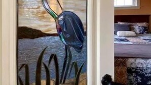 Ein Zimmer mit einem Bett, einem Fenster und einem Bild an der Wand.