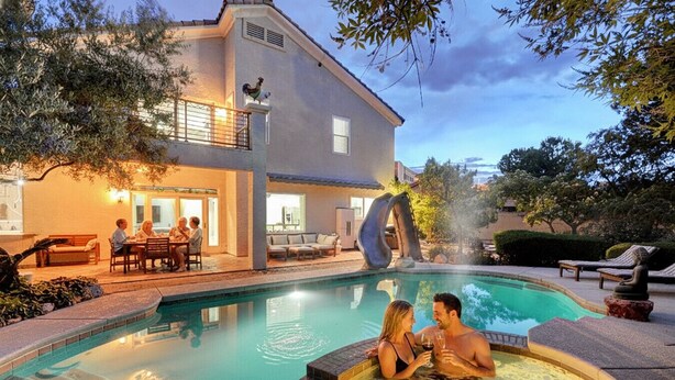 A swimming pool with a hot tub, outdoor seating, and a house with a balcony. - Buddha Estate, Pool , Spa, Sauna, Game Room (Las Vegas)