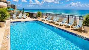 Una piscina con lettini e vista sull'oceano.
