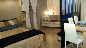 A hotel room with a bed, a sofa, a dining table with chairs, and a window with curtains. - very nice studio with real quiet bed at 1400m. from the center and the beaches (Menton)